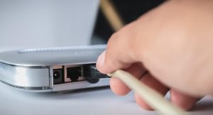 Przycięty ręczny kabel komputerowy przymocowany do routera