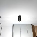 Czarne świece zamontowane w dużym lustrze w łazience widoczne oświetlenie LED w kształcie rury