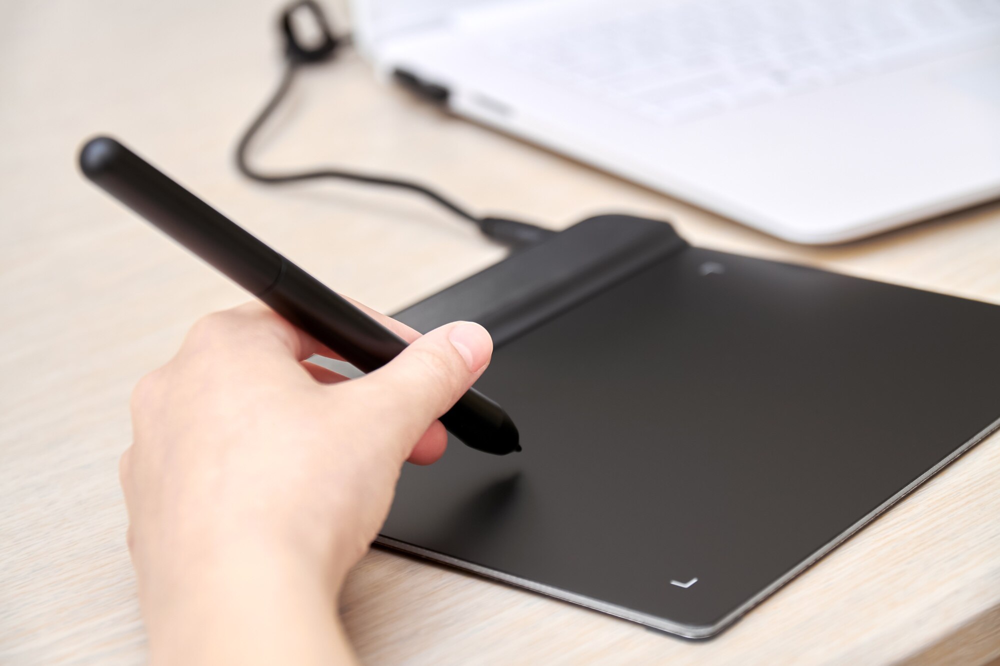 Dziewczyna rysuje na tablecie graficznym za pomocą pióra