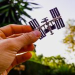 Zbliżenie modelu satelity w ręku na tle nieba