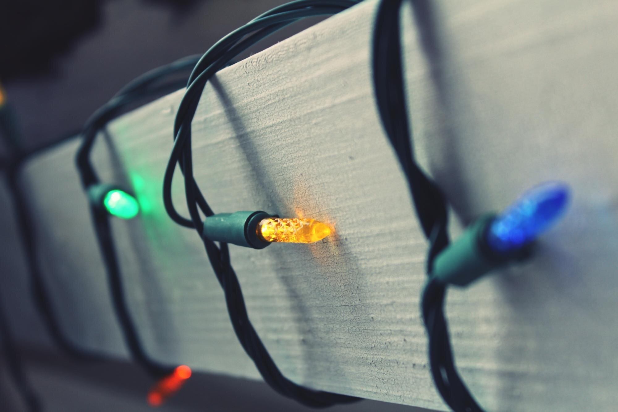 Zbliżenie kolorowych oświetlonych strun na drewnie