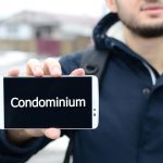 Mężczyzna trzymający telefon komórkowy z tekstem o mieszkaniu