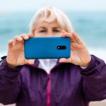 Turysta kaukaski blond kobieta robi zdjęcia lub nagrywa wideo przez telefon