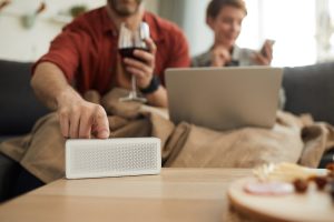 Zbliżenie: mężczyzna włącza radio na stole podczas picia wina z kobietą na kanapie