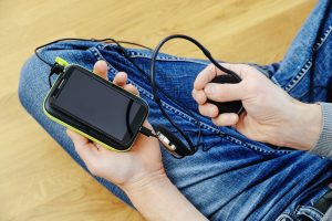 Mężczyzna ze słuchawkami, smartfonem i powerbankiem