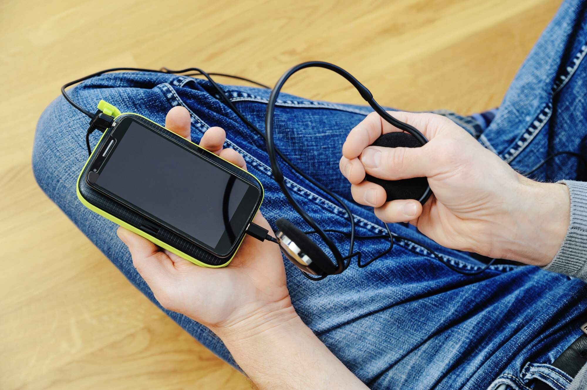 Mężczyzna ze słuchawkami, smartfonem i powerbankiem