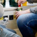 Środkowa sekcja mężczyzn siedzących podczas napełniania napoju za pomocą ładowarki