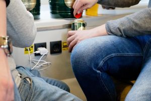 Środkowa sekcja mężczyzn siedzących podczas napełniania napoju za pomocą ładowarki