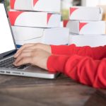 Środkowa sekcja mężczyzny używającego laptopa na stole