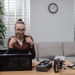 Młoda kobieta korzystająca z telefonu komórkowego siedząc w domu