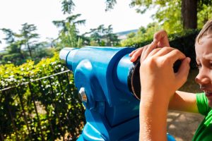 Chłopiec za pomocą ręcznego teleskopu