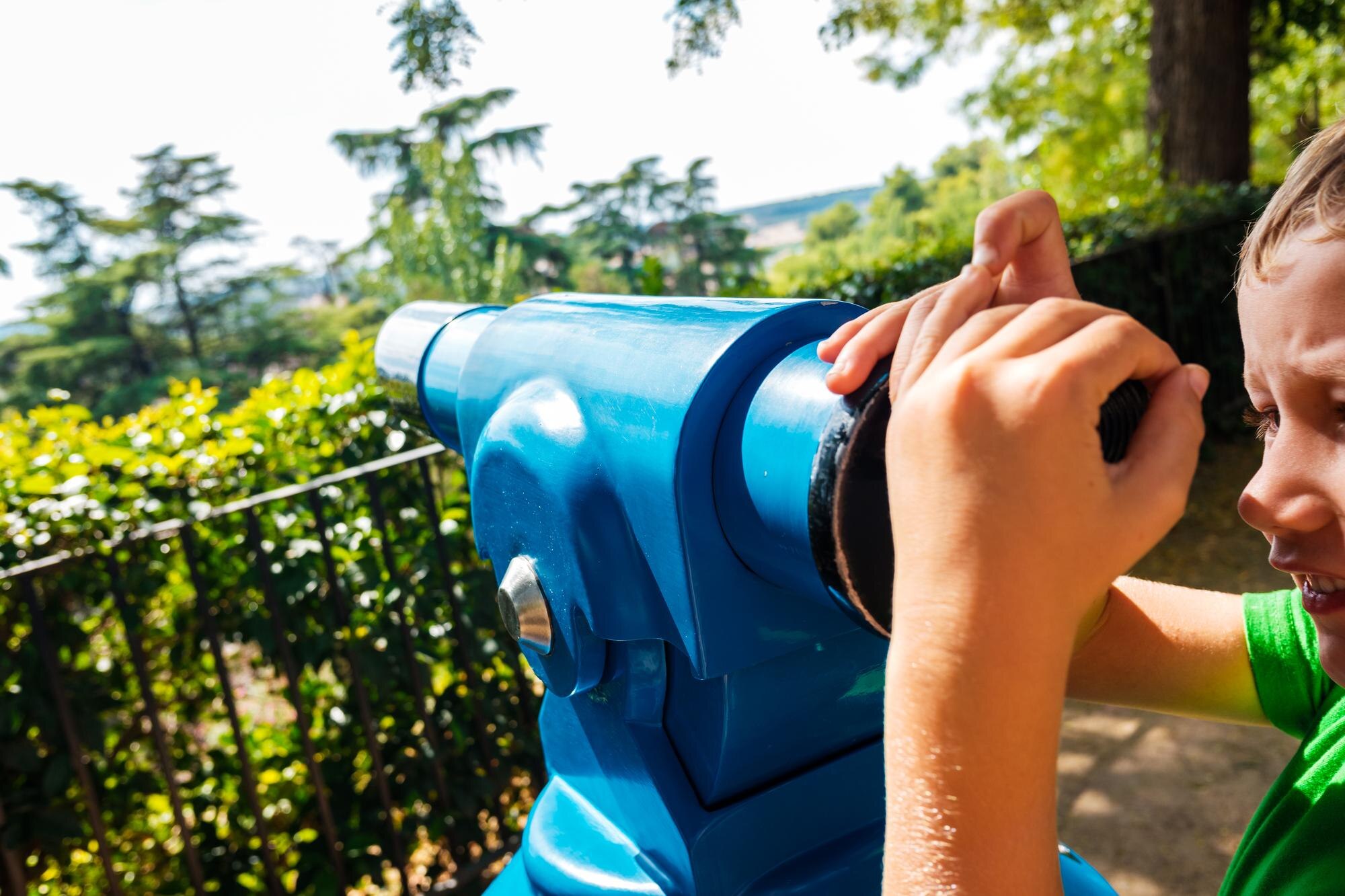 Chłopiec za pomocą ręcznego teleskopu