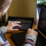 Kobieta pracująca w biurze z cyfrowym tabletem i notebookem pisząc i pisząc na urządzeniu