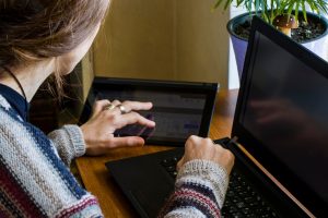 Kobieta pracująca w biurze z cyfrowym tabletem i notebookem pisząc i pisząc na urządzeniu