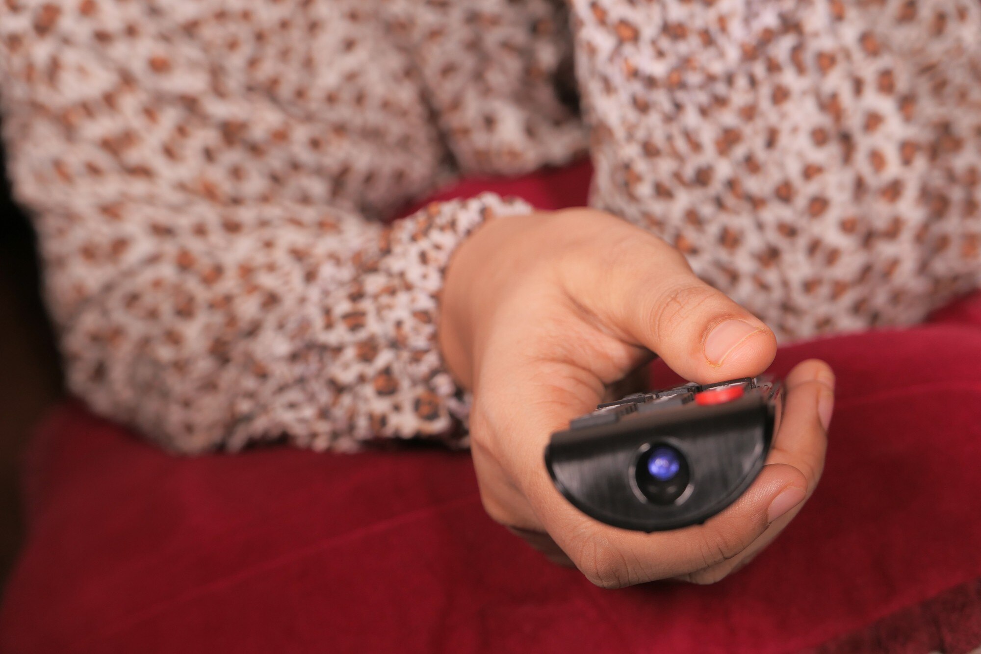 Bliska kobiety ręka trzyma pilota do telewizora