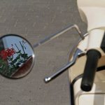 Kwiat odbijający się w oknie motocykla