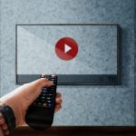 Środkowa część kobiety trzymającej czerwony balon przy ścianie