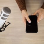 Widok z góry kobiety w studio radiowym ze smartfonem i mikrofonem