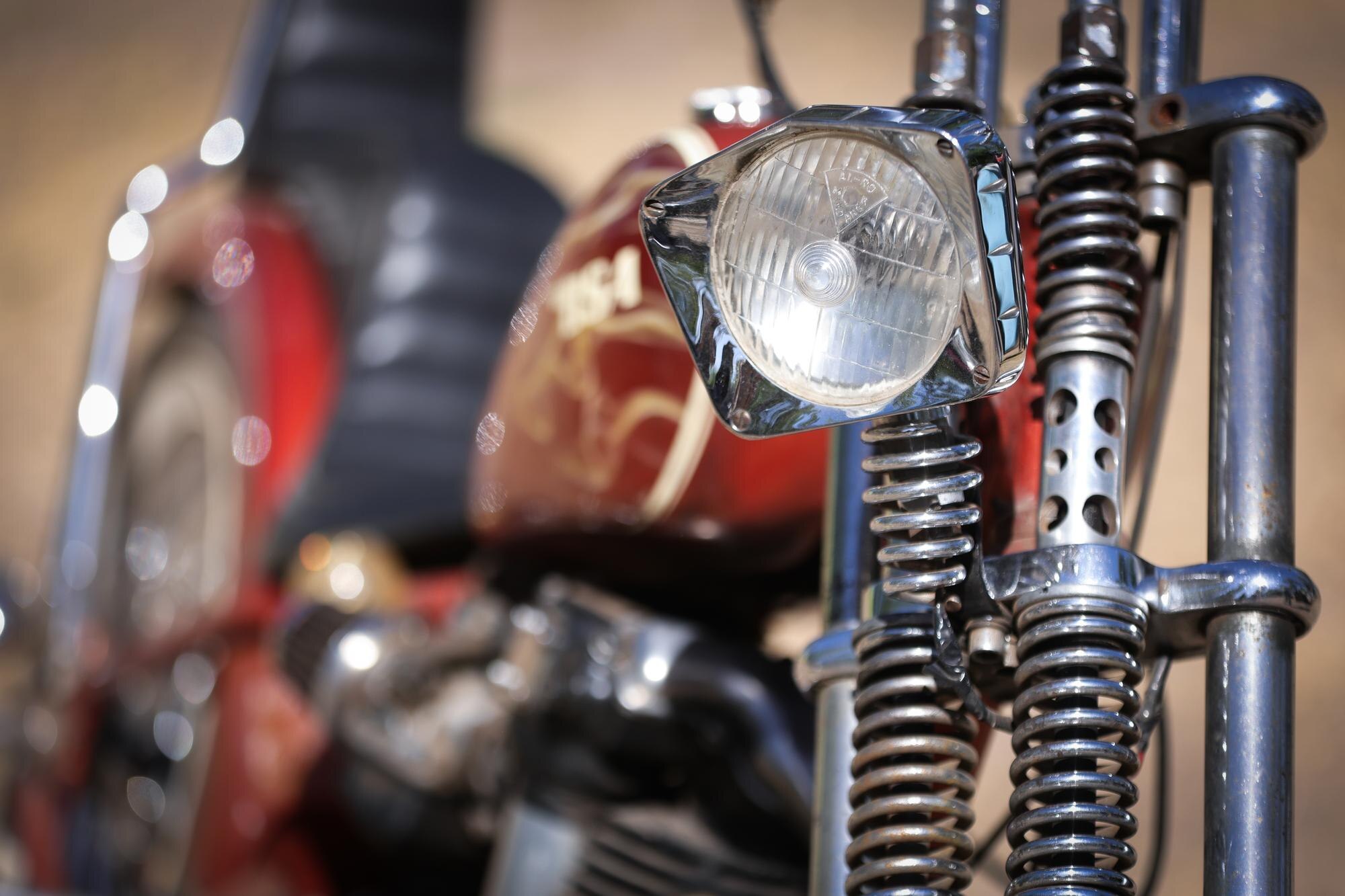 Stary motocykl z wieloma metalowymi częściami chromowanymi