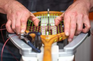 Proces naciągania historycznej lub retro rakiety tenisowej w sklepie tenisowym, koncepcja sportu i rekreacji