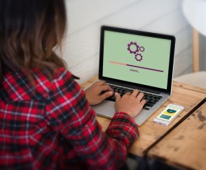 Z tyłu widok kobiety używającej laptopa na stole