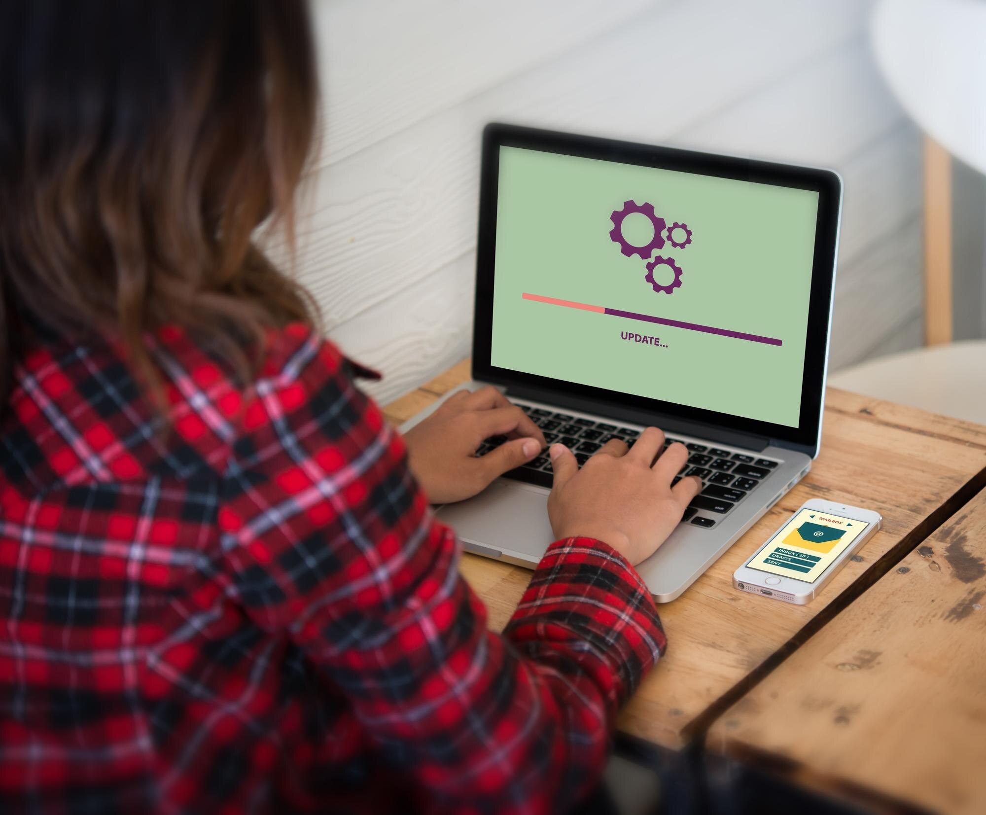 Z tyłu widok kobiety używającej laptopa na stole