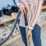 Gospodyni domowa. Zdjęcie kobiety trzymającej odkurzacz