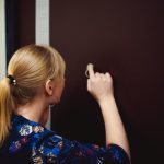 Tylny widok kobiety stojącej przy ścianie