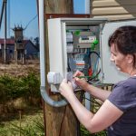 Wieśniaczka odczytuje licznik prądu.