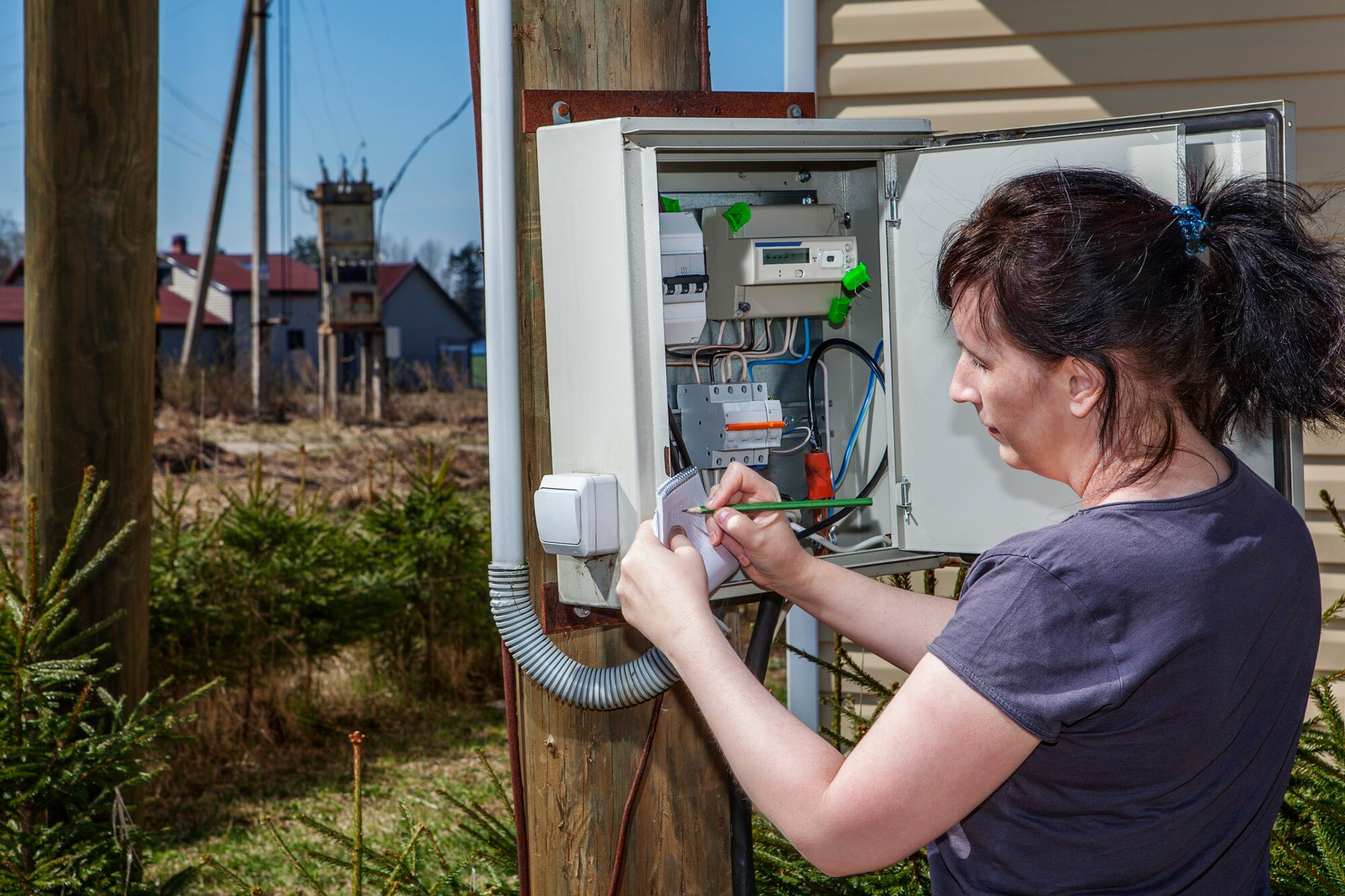 Wieśniaczka odczytuje licznik prądu.