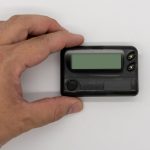 Zbliżenie ludzkiej ręki trzymającej sprzęt komputerowy na białym tle