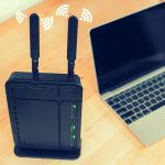 Zbliżenie routera za pomocą laptopa na stole