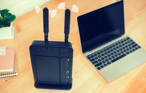 Zbliżenie routera za pomocą laptopa na stole