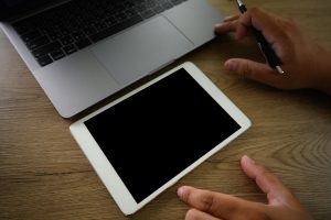 Dolna część osoby używającej telefonu komórkowego na stole