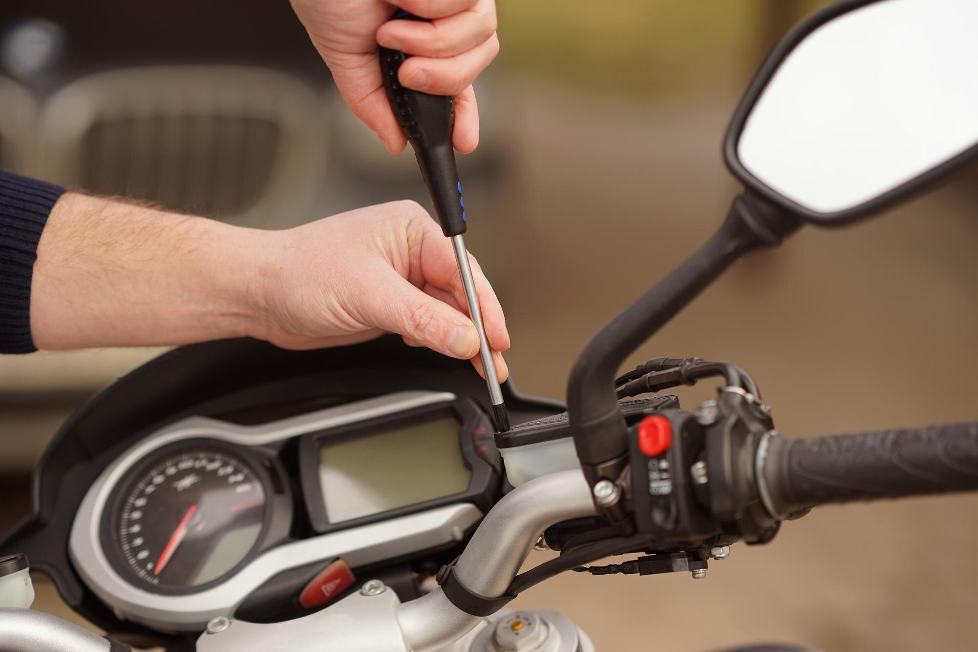 Zbliżenie mężczyzny trzymającego motocykl