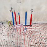 Rury z ciepłą i zimną wodą wychodzącą z podłogi i manometry zamontowane na końcach