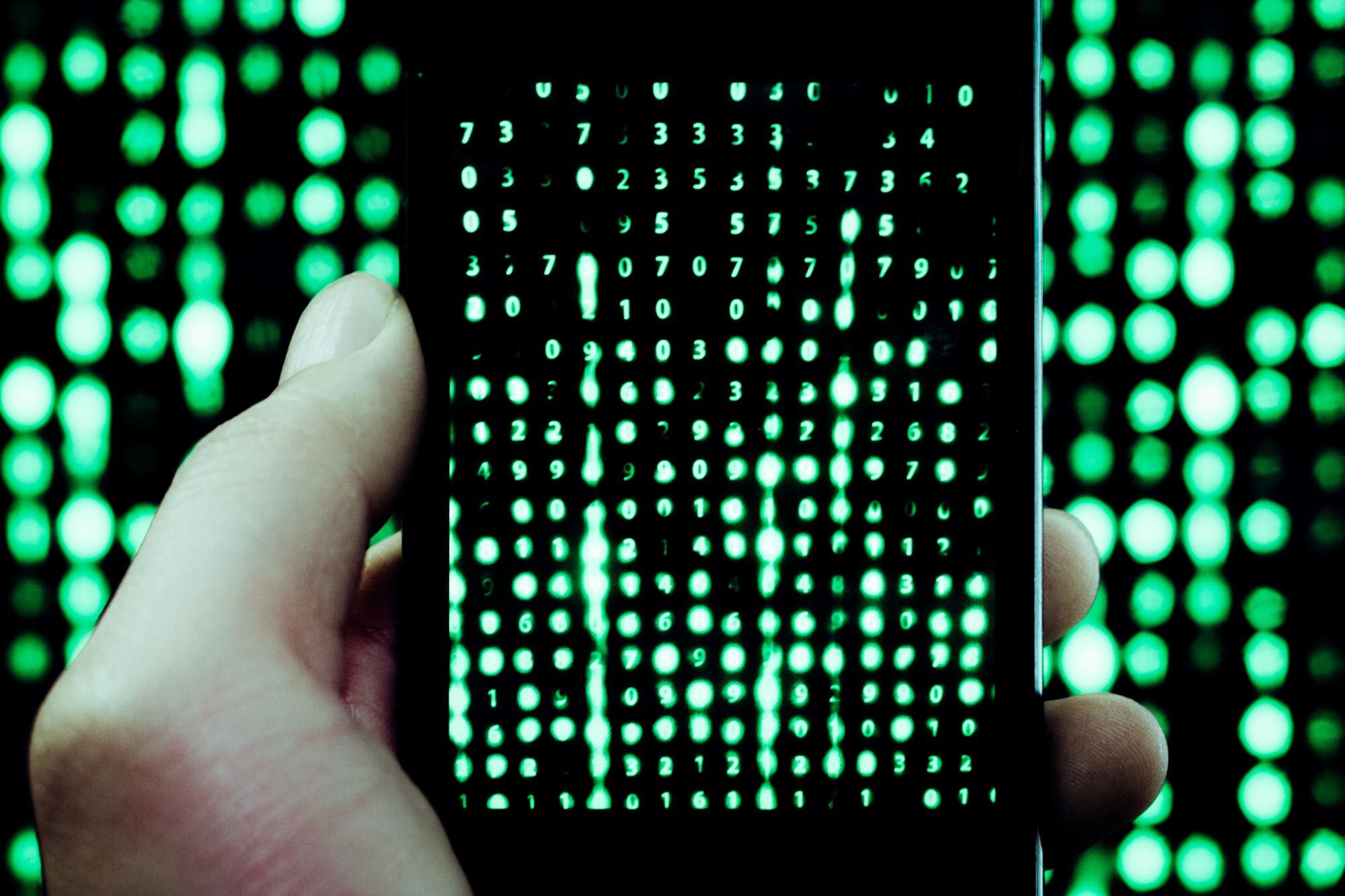 Przycięta ręka fotografująca język komputerowy za pomocą telefonu komórkowego