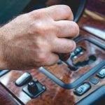 Kierowca ręka mężczyzna trzyma automatyczną skrzynię biegów w samochodzie. Męska ręka zmienia poziomy automatycznej skrzyni biegów w samochodzie.