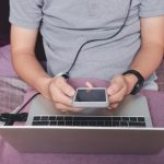 Mężczyzna trzymający smartfon w jednym rogu domowego biura.