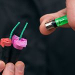 Podpalenie kilku petard. Mężczyzna w czarnych szatach zapala jednocześnie dwa petardy.