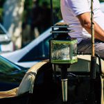 Mężczyzna trzymający kamerę stojący przy samochodzie