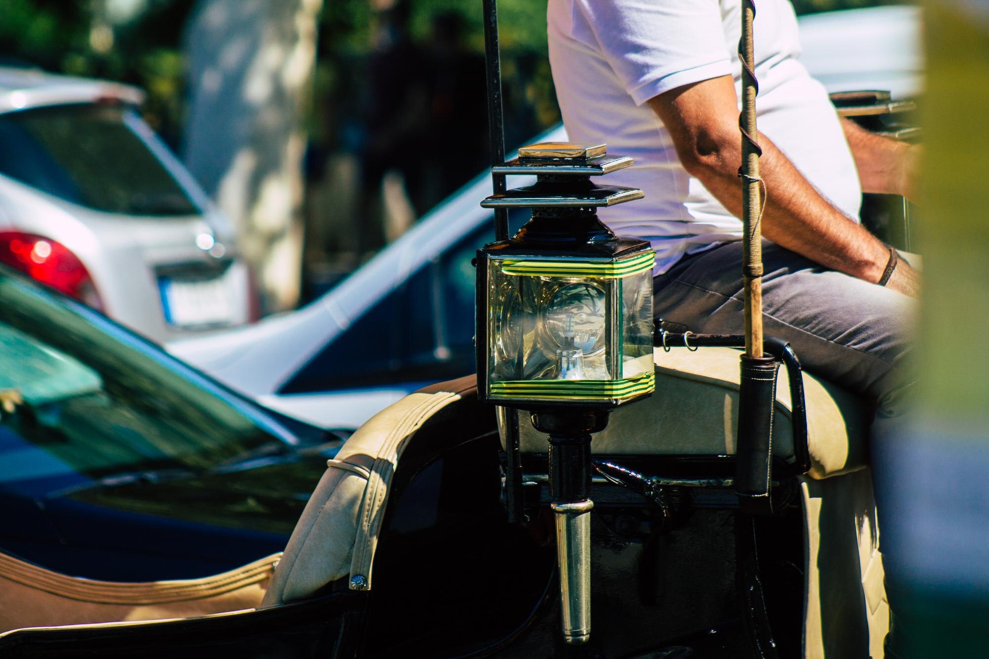 Mężczyzna trzymający kamerę stojący przy samochodzie