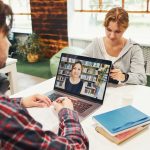 Studenci uczący się w bibliotece uniwersyteckiej młody człowiek mający zajęcia wideo na laptopie wraca do szkoły