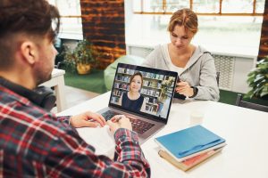 Studenci uczący się w bibliotece uniwersyteckiej młody człowiek mający zajęcia wideo na laptopie wraca do szkoły