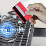 Cyfrowy kompozytowy obraz przyciętej ręki trzymającej kartę kredytową przez laptop na stole