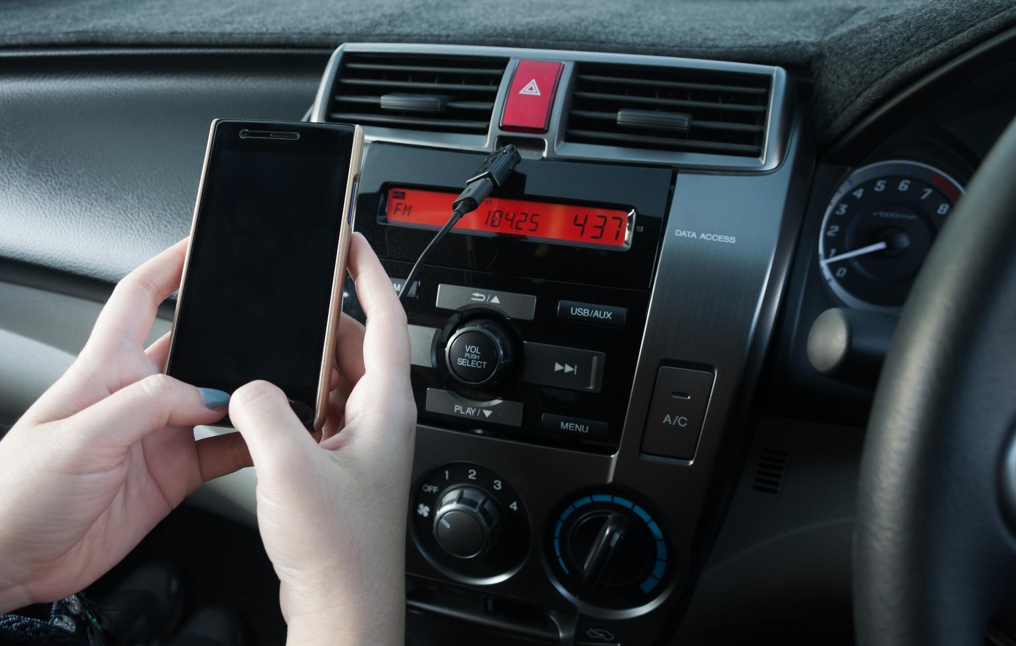 Przycięty obraz ręki używającej laptopa w samochodzie