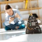 Urocze dzieciaki w wieku przedszkolnym oglądające warsztat pojazdów robotów