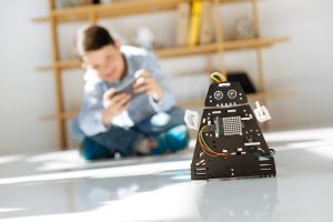 Urocze dzieciaki w wieku przedszkolnym oglądające warsztat pojazdów robotów