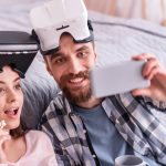 Proszę o uwagę. Cieszę się, że pozytywna para emocjonalna w okularach VR degustuje popcorn podczas robienia selfie i uśmiechniętego mężczyzny