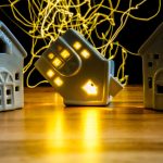 ceramiczny dom na boku koncepcja kryzysu mieszkaniowego jeden dom z włączonym światłem